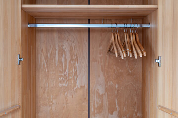 clothes hangers on rail in empty wardrobe