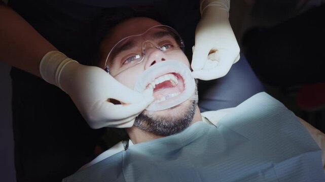 Dentist cleans a man's teeth. Hydience and healthy in modern clinic. Healthcare. Protective glasses