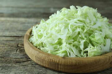 Fresh shredded cabbage on wooden table, closeup