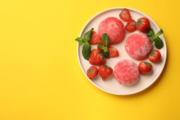 Delicious mochi, strawberries and mint on yellow table, top view. Space for text