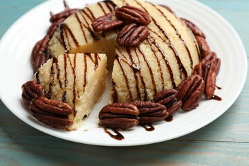 Delicious sweet semolina halva with pecans on blue wooden table, closeup