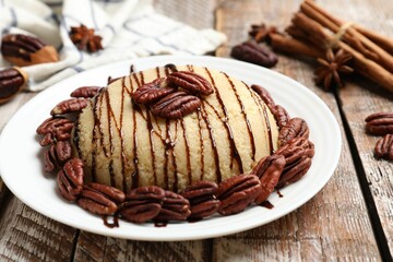 Delicious sweet semolina halva with pecans and spices on wooden table, closeup