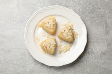 Pieces of delicious sweet semolina halva with almond flakes on light grey table, top view