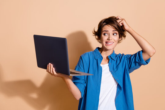 Photo of failed business lady in blue shirt scratching head when seeing low sales results company isolated on beige color background