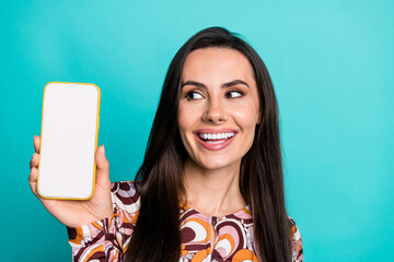 Photo of charming positive woman wear print shirt looking modern device empty space isolated teal color background