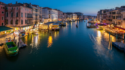 Naklejka premium Grand Canal in Venice, Italy day to night timelapse. Gondolas and city lights from Rialto Bridge.