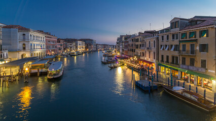 Obraz premium Grand Canal in Venice, Italy day to night timelapse. Gondolas and city lights from Rialto Bridge.