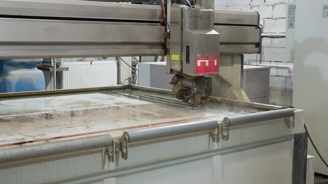 Automated saw is cutting the stone into the small slabs in a production workshop. Modern Industrial Processing CNC Saw Machine Spraying Water For Cooling. Manufacturing kitchen countertop quartz