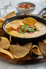 Mexican Queso Flameado or Fundido served in iron cast skillet with corn tortilla chips and Pico De Gallo