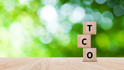 TCO concept. Total Cost of Ownership text on a wooden block, purchase price of an asset plus the costs of operation, business concept background