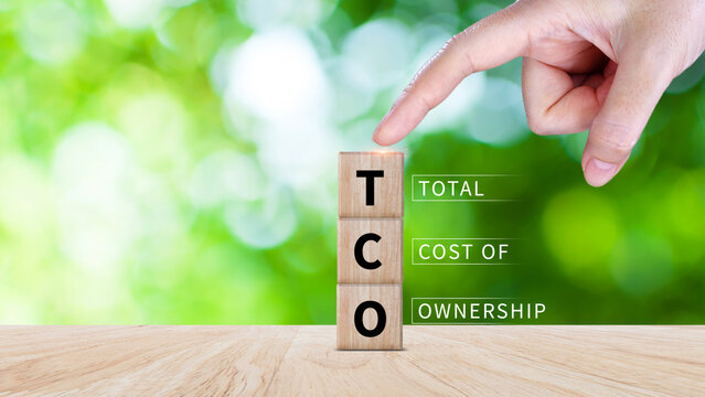 TCO concept. Total Cost of Ownership text on a wooden block, purchase price of an asset plus the costs of operation, business concept background