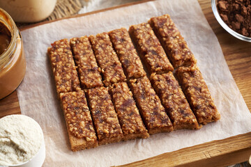 Homemade healthy bars made of whey protein powder, peanut butter, maple syrup and raw dates