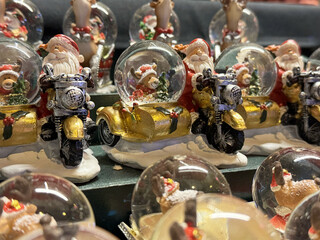 Festive santa figurines in snow globes on motorcycles with sidecars