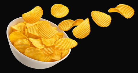 Falling ridged potato chips in bowl isolated on black background