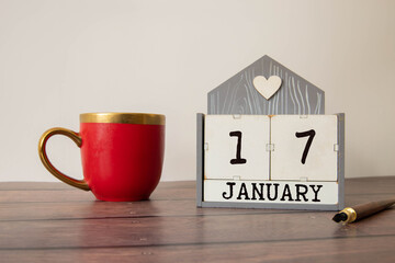 Cube shape calendar for January 17 on wooden surface with empty space for text