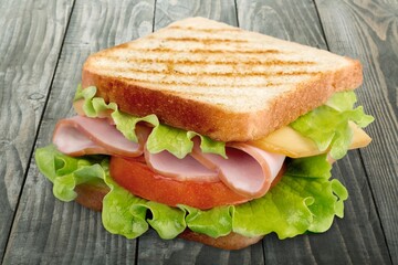Tasty fresh sandwich with vegetables on the desk