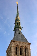 Obraz premium A gilded copper statue of Saint Michael tops the AD 1897, neo-Gothic spire erected over Le Mont-Saint-Michel Romanesque belfry. Normandy-France-109