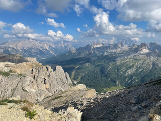 Scenic view of the Dolomites from a hiking trail near Cortina d’Ampezzo, showcasing stunning rocky mountains and lush greenery in summer.