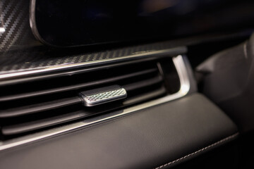 Closeup of car dashboard air vents near gear shift