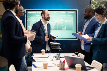 Teammates assembling in a room for meetings to go over their results after examining graphic representations and feedback from stakeholders. Staff and team leader exchange perspectives.