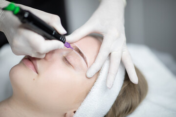 Woman enjoy a pampering session at a beauty salon, receiving a permanent makeup procedure. The artist carefully applies makeup for long-lasting results on their brows.