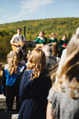 People gathered together singing at a wedding ceremony in Ontario, Canada.