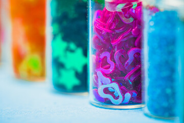 Obraz premium Small glass jars filled with various types of glitter. Jars with multicolored glitter. The vibrant colors and shiny textures. Arts, crafts, decoration, creativity concepts 