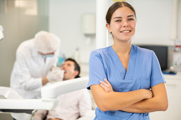 In dentists office, girl nurse before start of appointment and working day. Positive medical...