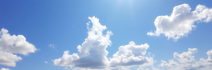 Bright blue sky with fluffy white clouds on a summer day, tranquil, clear skies