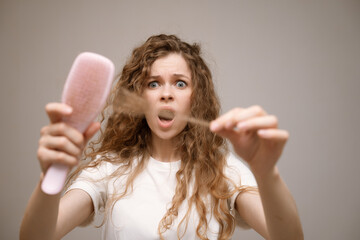 Woman scared, nervous, expression as she notices hair thinning and hair falling out. Hair loss...