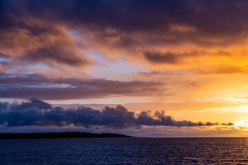 Serene Sunrise Over Calm Waters and Dramatic Cloudscape