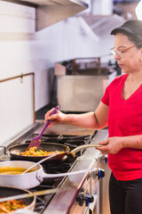 Latin american chef cooking traditional ecuadorian food in restaurant kitchen