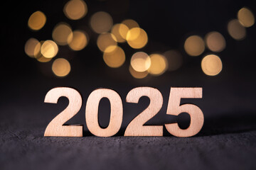 New Year 2025 in wooden numbers with bokeh