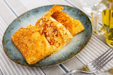 Appetizing baked pancakes stuffed with liver and egg served on plate..