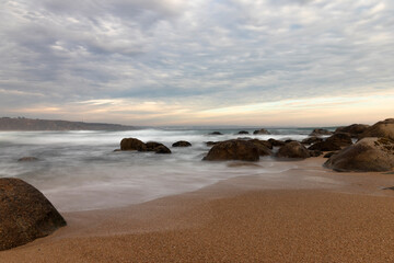 olas y rocas en la costa de la playa al atardecer