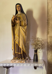 Korcula, Croatia - June 30, 2024: Saint Mark Cathedral. Statue of Saint Theresa of the child Jesus, also known as Theresa of Lisieux, or The Little Flower. She holds cross in her hand. Flowers on the 