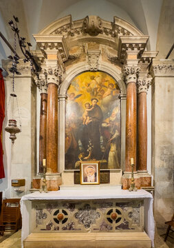 Korcula, Croatia - June 30, 2024: Saint Mark Cathedral. Side altar with Saint Anthony painting set in monumental niche with sculpted columns and arch.