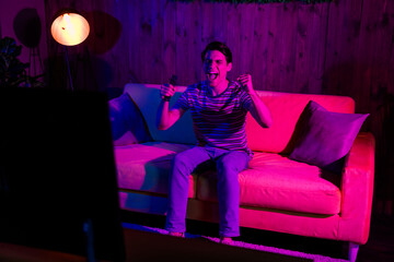 Young man enjoying a leisure moment in a stylish living room setting during a relaxing weekend