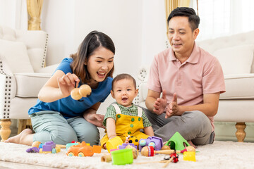 Asian family mother,father ,son playing with colorful kid toys. Happy baby boy in kindergarten or daycare. Child playing with colorful educational toys in preschool. Asian woman. Happy family.