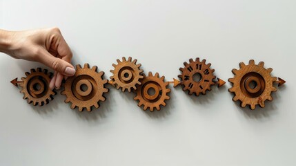 Hand arranging wooden gears in a process flow, representing workflow, teamwork, or mechanism.