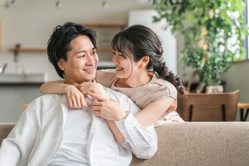 家のリビングで男性に抱きつく女性(夫婦・カップル・恋人)
