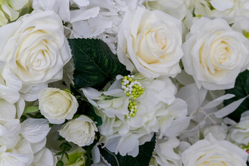 Beautiful arrangement of white roses and greenery in floral display