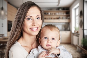 Loving mother carrying newborn baby at home.