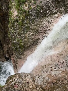 Cascading waterfalls lead a light green colored stream flowing down a beautiful gorge.