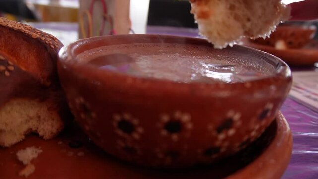 Dejar el pan de yema remojar en el chocolate caliente. Bebida oaxaque&ntilde;a.