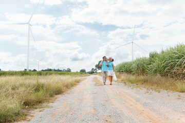Obraz premium Happy cheerful caucasian white family with daughter are walking and relaxing together in the daytime in nature with windmill towers in background. Happy family activity concept.