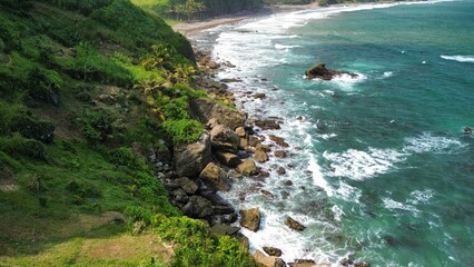 Aerial drone view of coastline with hills and trees, as well as view of coral cliffs and sea with...