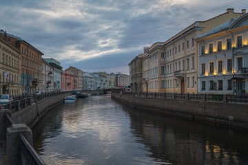 Naklejka premium Moika River Embankment and Bolshoy Konyushenny Bridge on a cloudy spring morning, Saint Petersburg, Russia