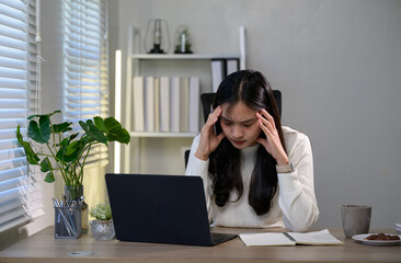 Young professional woman experiencing a migraine or being tired and suffering from stress because...