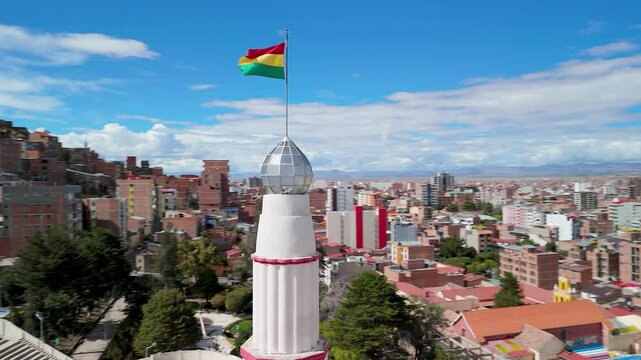 Aerial of Lighthouse with Bolivia Flag and city of Oruro, Orbit